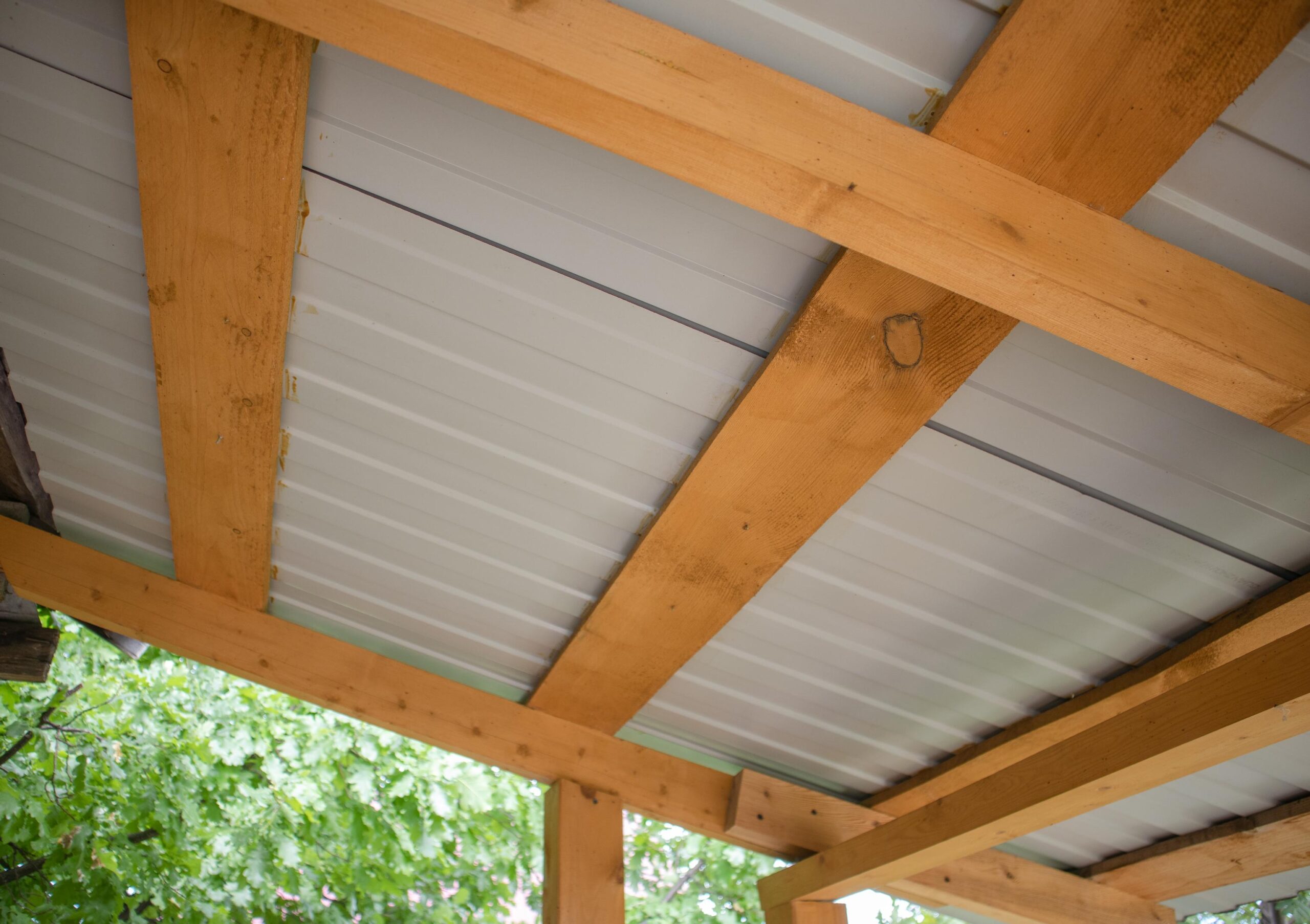 Close-up of wooden roof rafters with metal corrugated board, bottom view