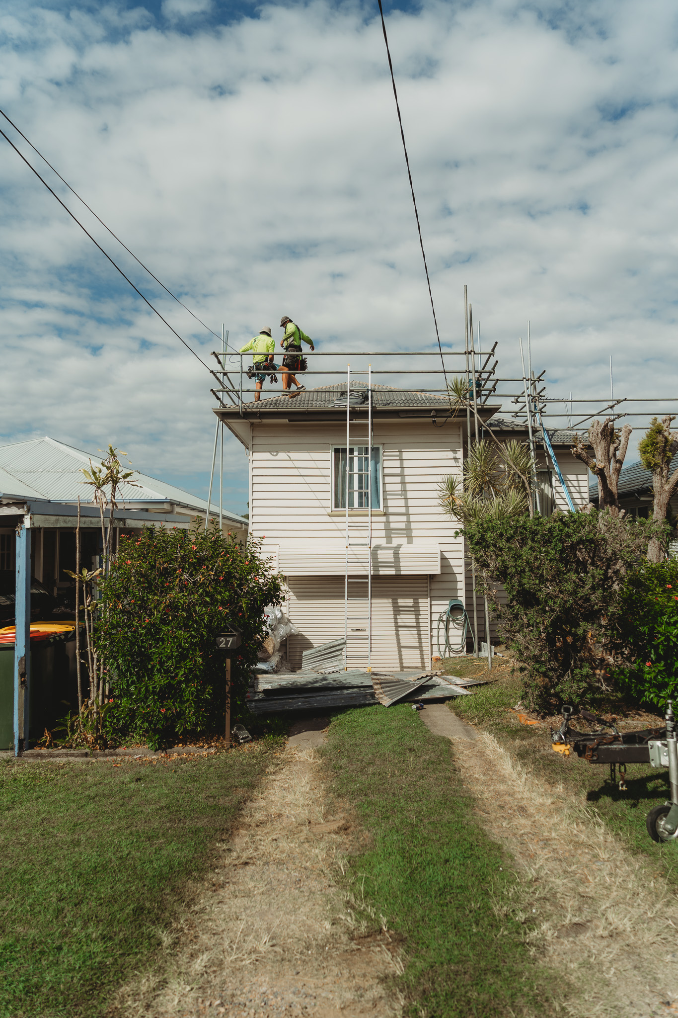 Roofing team working on a residential roof replacement with scaffolding in place