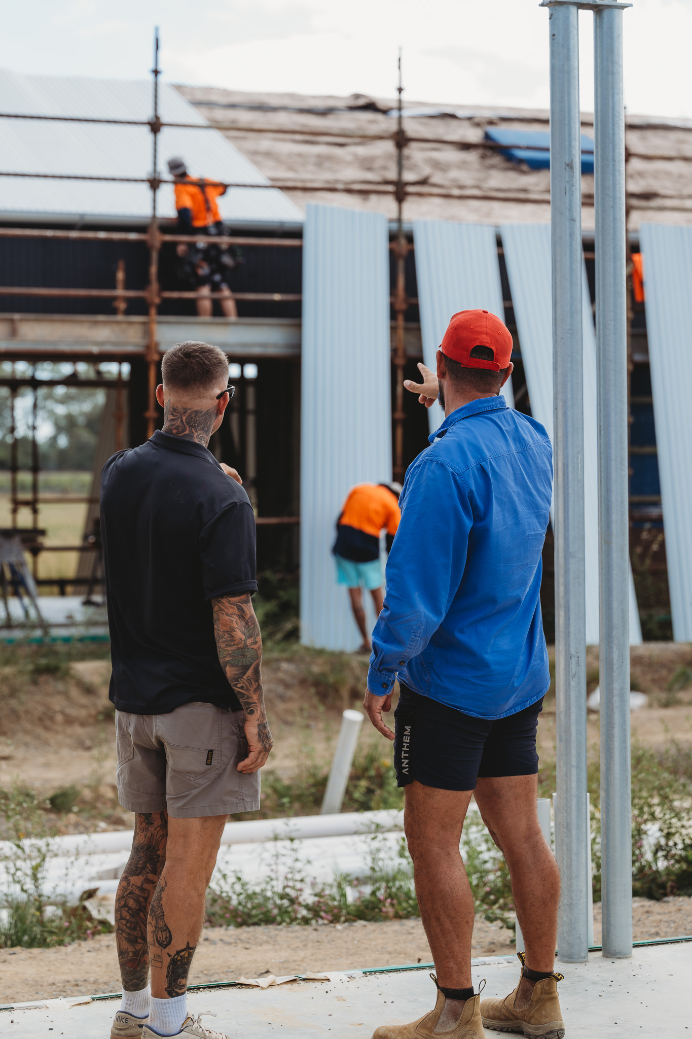 Roofing contractors inspecting a residential metal roof installation on site