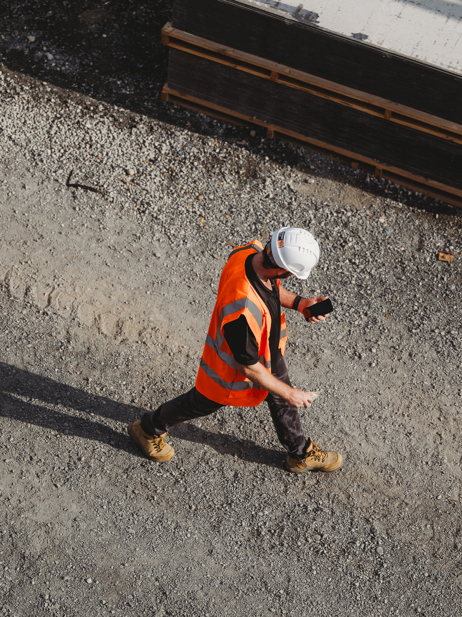 Construction worker walking through a commercial building site wearing safety equipment