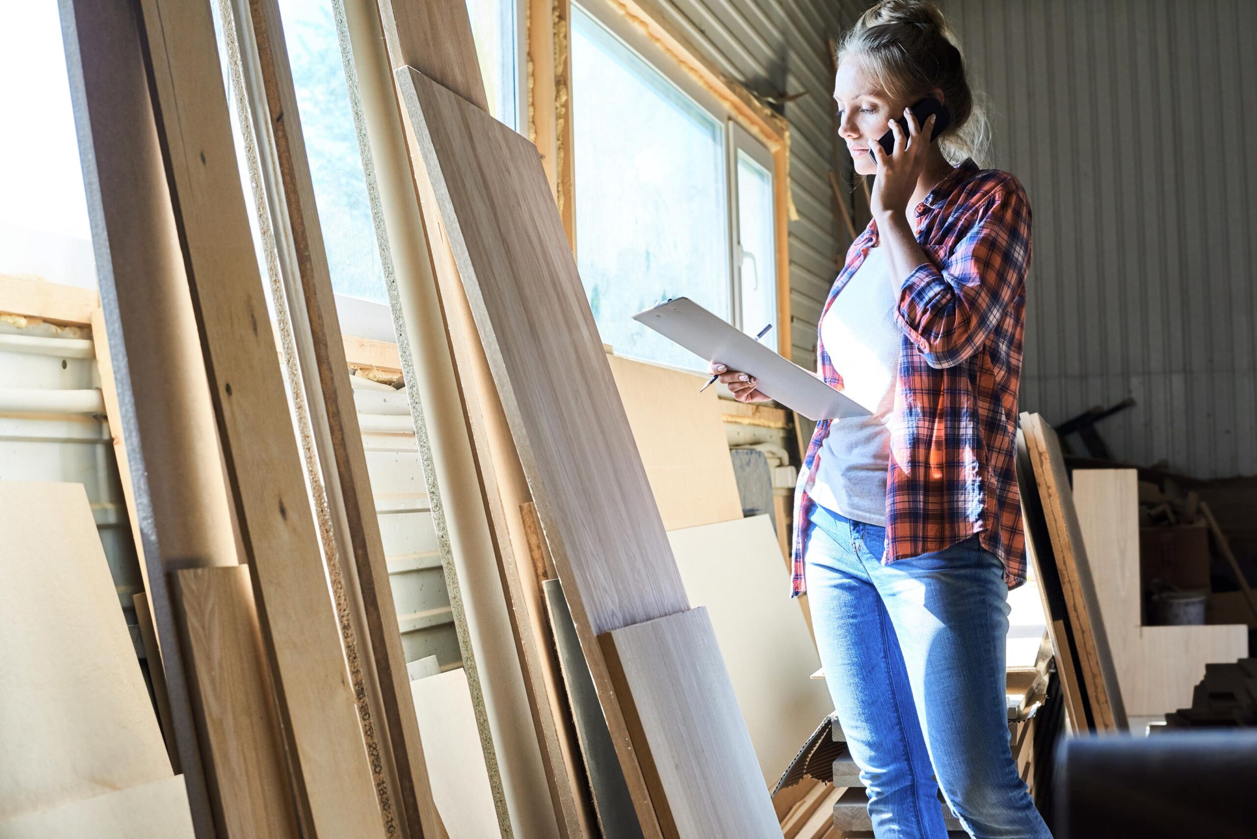 Woman Discussing Wood Order in Workshop